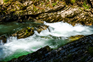 minimalist close-up of a river in a rocky canyon with lush greenery. clear water and dynamic flow. nature wallpapers