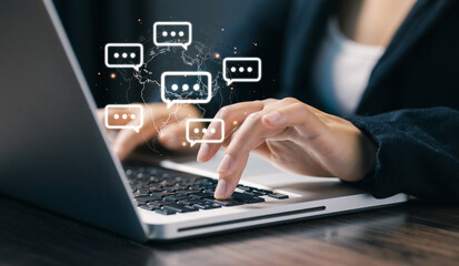 Hands typing on a laptop with floating chat bubbles over a world map, representing global online communication, instant messaging, remote collaboration, and digital business interaction.