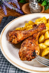 Baked chicken drumsticks with potatoes.