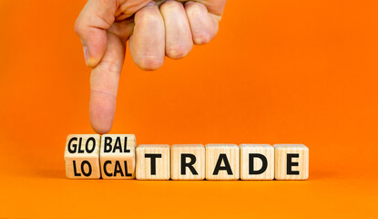 Global or local trade symbol. Concept words Global trade Local trade on beautiful wooden blocks. Beautiful orange background. Businessman hand. Business Global or local trade concept. Copy space