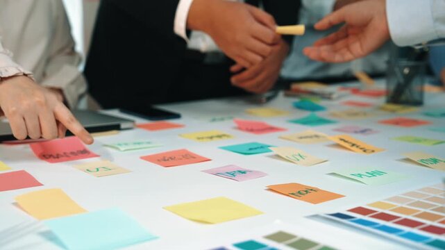 A modern office scene featuring a laptop and vibrant sticky notes laid out on a table. This image captures the essence of collaboration and creativity in a professional environment. SACTR