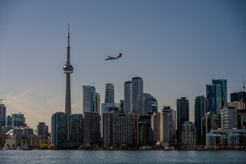 Obraz premium Airplane flying over downtown skyline and CN Tower in Toronto