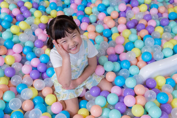 Child plays happily in colorful ball pit