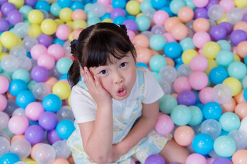 Child plays happily in colorful ball pit