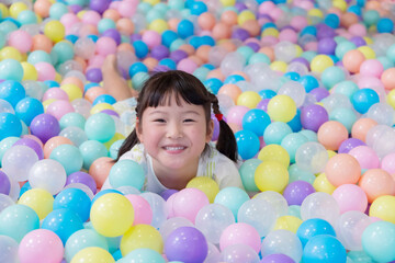 Child plays happily in colorful ball pit