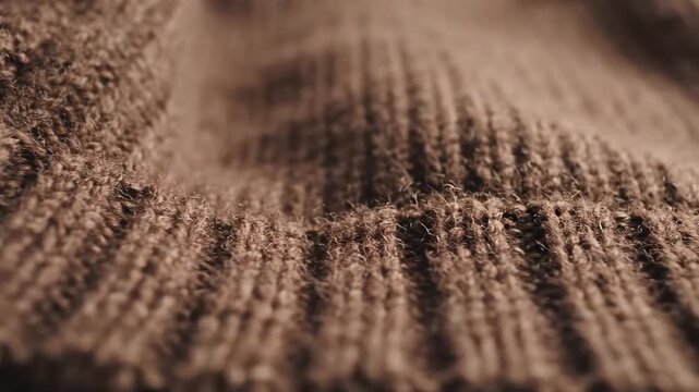Close-up of a brown knitted fabric with intricate patterns and textures, showcasing the warmth and craftsmanship of textile art.