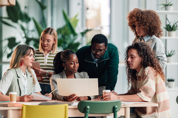 Diverse startup team collaborating on project in modern office