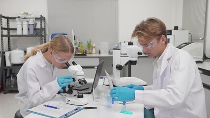 Students conduct research in science lab using microscope and laptop for data analysis - Powered by Adobe