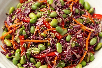Healthy Edamame Salad with carrots, bell peppers, red cabbage, green onion and sesame seeds.