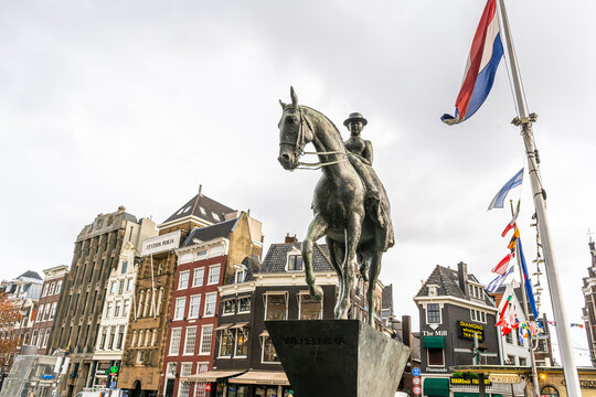 Netherlands, Amsterdam - 28 October 2025: Equestrian statue of Queen Wilhelmina in Amsterdam. Holland flag. Horse monument sculpture
