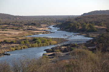 View of winding river with vegetation and rocks. Taken in Kruger National Park, South Africa.