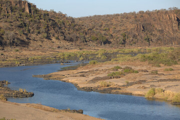 View of winding river with vegetation and rocks. Taken in Kruger National Park, South Africa.