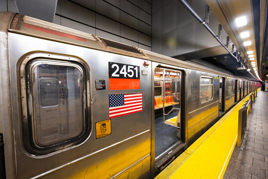 New-York, USA - 13.12.2025: New York city subway train with open doors and american flag at underground station platform