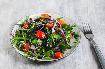 Close-up of vegetarian salad with vegetables and herbs on a plate on the table