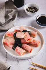 Fried spring rolls with crab sticks and nori on a plate on the table vertical view