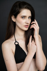 Young brunette woman studio portrait with natural beauty and emotional expressions, close up face, healthy skin, minimal fashion style, modern people and lifestyle concept