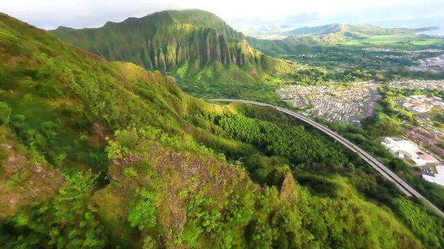 Epic aerial view of a highway through the lush mountans of Oahu, Hawaii.