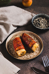 Sweet and Savory Baked Banana Wrapped in Bacon on a Plate on the Table vertical view