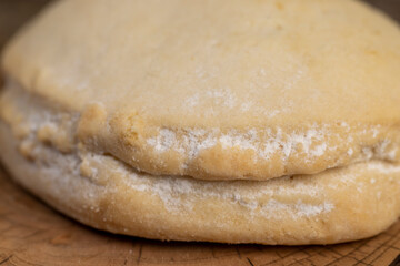 a whole fresh shortbread bun with cottage cheese filling on a board on the table, soft pastries stuffed with cottage cheese and sugar are on the board