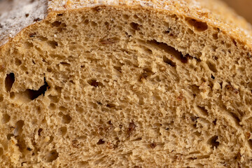 fresh soft loaf of bread on black slate, freshly baked soft loaf of rye bread cut in half