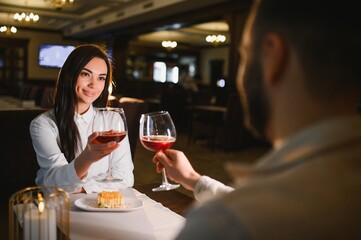 Couple toasting red wine celebrating love in restaurant
