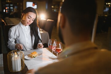 Couple dining in restaurant enjoying romantic evening with dessert