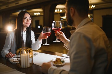 Couple toasting wine during romantic dinner date in restaurant
