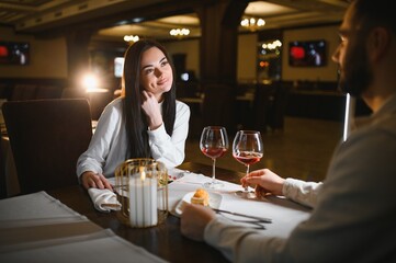 Happy couple enjoying romantic candlelit dinner together