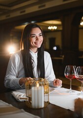 Happy woman enjoying romantic dinner at restaurant