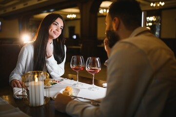 Romantic couple enjoying anniversary dinner at elegant restaurant