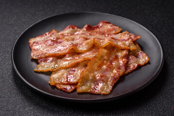 Fried smoked bacon slices, ham, jamon, or prosciutto strips for cooking. Fried bacon