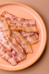 Fried smoked bacon slices, ham, jamon, or prosciutto strips for cooking. Fried bacon
