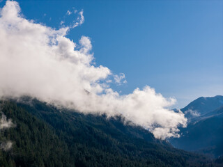 Majestic Mountain Valley Scene With Clouds Over Forested Peaks in British Columbia, Canada