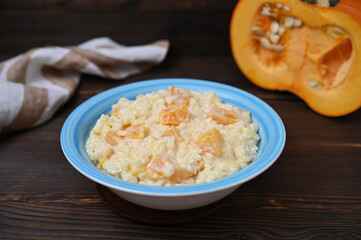 still life with pumpkin rice porridge and pumpkin on a wooden background