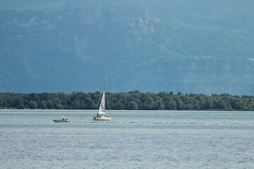 Sailboat on Calm Lake with Mountains in the Background