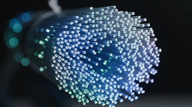 Macro view of glowing blue fiber optic cable bundle on black background representing high-speed data transmission