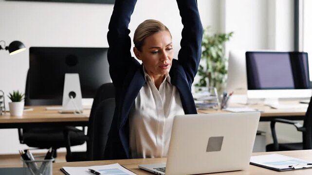 Tired businesswoman stretching at her office desk. Female employee taking a break to relieve stress and fatigue from work. Workplace wellness concept