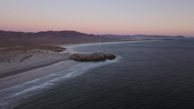 Cinematic Drone Flight Ove Coastal Beach and Rocky Iland at Dusk