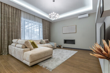 Modern design of the living room with a cozy sofa, elegant curtains and modern decor in a well-lit room.