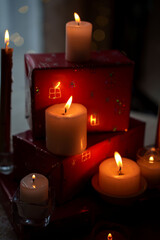 warm candlelit ambiance with festive wrapped gifts creating a cozy and inviting atmosphere, illuminated by gentle candle flames and soft light reflections on present boxes, texture, detail