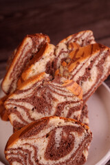 close-up of multiple thick slices of marbled chocolate and vanilla sponge cake arranged on a white plate, highlighting their intricate swirled pattern and rich textures, plating, treats, arrangement