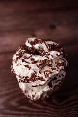 close-up of a whipped cream topped dessert with rich chocolate sprinkles on dark wooden background capturing luxurious texture and indulgent sweetness, decorative, mocha, brownie, richness