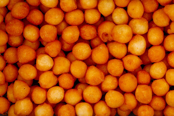 Cheesy orange crunchy snack balls filling frame