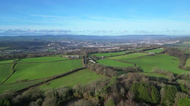 Coffinswell, South Devon, England: DRONE VIEWS: The drone flies over farmland heading towards the market town of Newton Abbot. UK green belt land is increasingly under threat from urban development.