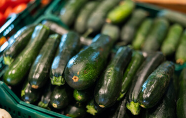 Green zucchini in shop window. Stocks of fruits in stores storage. Fresh fruit vegetable harvest from producer is already on store shelves.