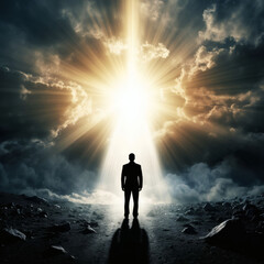 Man standing alone facing bright light in dramatic cloudy landscape  