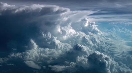 A collection of clouds forming at a high altitude. The sky displays shades of blue white and gray as the clouds shift and change shape. Looks like the view is from an airplane.