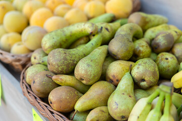 View of ripe pears in a wicker basket, put up for sale in a store