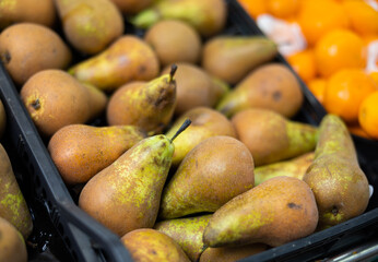 View of ripe pears in a wicker basket, put up for sale in a store