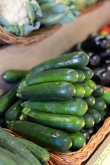 Pyramid of zucchini is laid out on shop window. Various varieties of green marrow squash are presented in greengrocers shop. .
